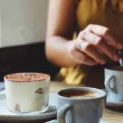 A woman enjoying her cup of coffee and pastry.